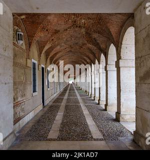 Grande corridoio esterno simmetrico con archi e colonne nel vecchio palazzo reale di Aranjuez. Madrid. Foto Stock