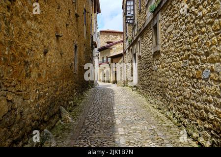 Vicolo stretto con vecchie case in pietra e archi di edifici medievali. Santillana del Mar, Santander. Foto Stock