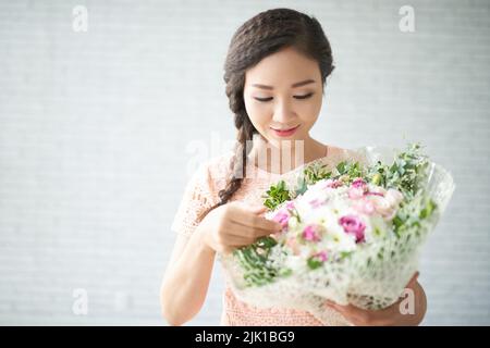 Bella giovane donna asiatica con grande bouquet di fiori Foto Stock