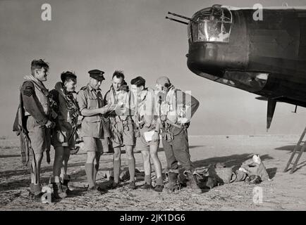 L'equipaggio di un Vickers Wellington Mark X di 150 Squadron RAF riceve un briefing finale dal loro comandante di volo prima del decollo da Kairouan, Tunisia, per un raid su bersagli nella zona salernitana il giorno prima degli sbarchi alleati. Il Wellington era un bombardiere medio a lungo raggio a doppia potenza, progettato a metà del 1930s, utilizzato come bombardiere notturno nei primi anni della seconda guerra mondiale, fino a quando non è stato sostituito dalle più grandi 'giovie' a quattro engineed come l'Avro Lancaster. Si distingue per essere stato l'unico bombardiere britannico prodotto per tutta la durata della guerra. Foto Stock