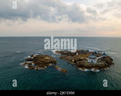 Vista aerea di un piccolo santuario e padiglione su un'isola rocciosa all'alba Foto Stock