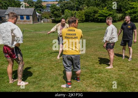 Allenatori che insegnano le regole e le tecniche di Cornish Wrestling prima dell'inizio del Grand Cornish Wrestling Tournament sul pittoresco villaggio g Foto Stock