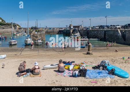 I turisti si godono il sole glorioso su una staycation nel pittoresco porto di Newquay in Cornovaglia in Inghilterra nel Regno Unito. Foto Stock