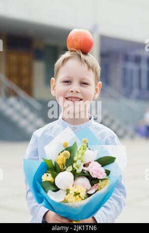 Ritratto di una giovane e bella di prima della livellatrice con bouquet in una scuola uniforme sulla scuola di sfondo. Addio Bell. Giorno della conoscenza. inizio del th Foto Stock