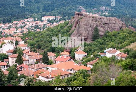 La città di Belogradchik si trova sotto la Rocca Rocks in Bulgaria. Vedrete i tetti di tegole rosse delle case sulle pendici nord dei Monti Balcanici. Foto Stock