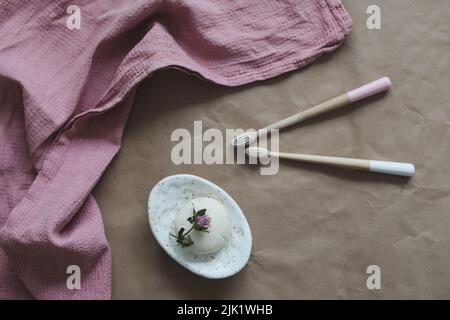 Saponetta, spazzolino da denti di bambù e asciugamani vista dall'alto. Accessori per l'igiene personale. Prodotti per la casa privi di plastica ed ecologici Foto Stock