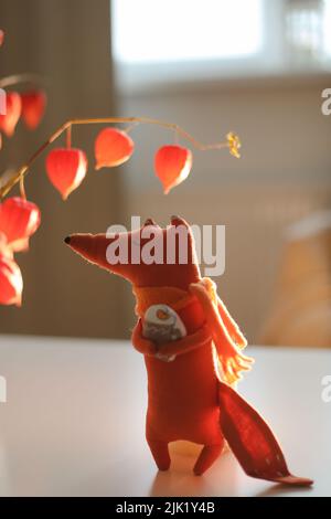 autunno natura morta con una volpe giocattolo, fiori, ramoscelli di physalis rosso in un vaso in una casa accogliente interno Foto Stock