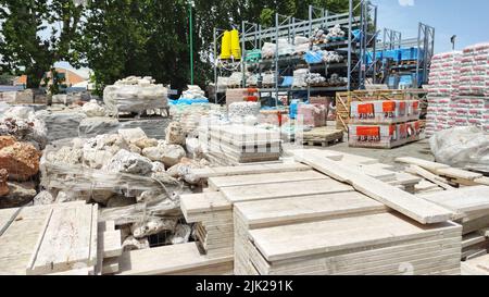 pallet e confezioni di mattoni rossi prodotti di fresco in un magazzino di costruzione sulla strada. Concetto di riparazione e materiali da costruzione Foto Stock