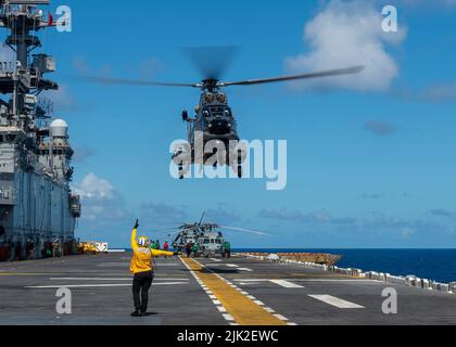 OCEANO PACIFICO (27 luglio 2022) U.S. Navy Airman Shaion Plummer, da New York City, segnala ad una Marina cilena AS-532 Cougar sul ponte di volo della nave d'assalto anfibio USS Essex (LHD 2) della Marina degli Stati Uniti durante il Rim of the Pacific (RIMPAC) 2022 luglio 27. Ventisei nazioni, 38 navi, tre sommergibili, più di 170 aerei e 25.000 persone partecipano a RIMPAC dal 29 giugno al 4 agosto nelle Isole Hawaii e nella California meridionale. Il più grande esercizio marittimo internazionale del mondo, RIMPAC offre un'opportunità di formazione unica, promuovendo e sostenendo al contempo i cooperati Foto Stock