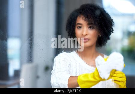 Una superficie chiara è una superficie pulita, una giovane donna che pulisce le finestre. Foto Stock