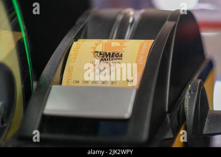 Los Angeles, California, Stati Uniti. 29th luglio 2022. Un cassiere stampa un biglietto per la lotteria Mega Millions mentre le persone aspettano in fila al negozio di liquori Blue Bird a Hawthorne, California, venerdì 29 luglio 2022. (Credit Image: © Ringo Chiu/ZUMA Press Wire) Credit: ZUMA Press, Inc./Alamy Live News Foto Stock