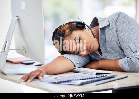 Agente del call center stanco e addormentato in ufficio nel pomeriggio. Giovani donne d'affari esauste che riposano sulla scrivania in un ufficio. Sensazione femminile Foto Stock