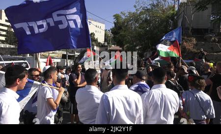 Gerusalemme, Israele. 29th luglio 2022. GERUSALEMME, ISRAELE - LUGLIO 29: I contromanifestanti di destra detengono bandiere israeliane e la bandiera del partito Likud mentre affrontano attivisti di sinistra israeliani e palestinesi che detengono bandiere palestinesi durante una manifestazione contro l'occupazione israeliana e l'attività di insediamento nel quartiere di Sheikh Jarrah il 29 luglio 2022 a Gerusalemme, Israele. Il quartiere palestinese di Sheikh Jarrah è attualmente il centro di una serie di controversie di proprietà tra palestinesi e israeliani ebrei di destra. Alcune case sono state occupate dai coloni israeliani a seguito di una sentenza della Corte Foto Stock