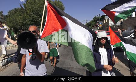 Gerusalemme, Israele. 29th luglio 2022. GERUSALEMME, ISRAELE - 29 LUGLIO: Gli attivisti israeliani di sinistra e i palestinesi detengono bandiere palestinesi e grida slogan durante una manifestazione contro l'occupazione israeliana e l'attività di insediamento nel quartiere di Sheikh Jarrah il 29 luglio 2022 a Gerusalemme, Israele. Il quartiere palestinese di Sheikh Jarrah è attualmente il centro di una serie di controversie di proprietà tra palestinesi e israeliani ebrei di destra. Alcune case sono state occupate dai coloni israeliani a seguito di una sentenza della Corte. Credit: Eddie Gerald/Alamy Live News Foto Stock