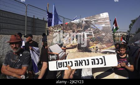 Gerusalemme, Israele. 29th luglio 2022. GERUSALEMME, ISRAELE - LUGLIO 29: Un attivista israeliano di sinistra ha un cartello che mostra una casa palestinese demolita con scritto, "questo è ciò che l'occupazione sembra” durante una manifestazione contro l'occupazione israeliana e l'attività di insediamento nel quartiere di Sheikh Jarrah il 29 luglio 2022 a Gerusalemme, Israele. Il quartiere palestinese di Sheikh Jarrah è attualmente il centro di una serie di controversie di proprietà tra palestinesi e israeliani ebrei di destra. Alcune case sono state occupate dai coloni israeliani a seguito di una sentenza della Corte. Credito: EDD Foto Stock