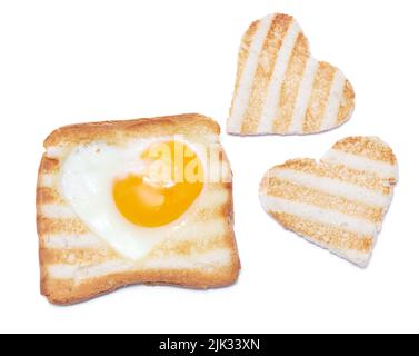 Uova fritte a forma di cuore in un pane tostato con segni di griglia isolato su sfondo bianco Foto Stock