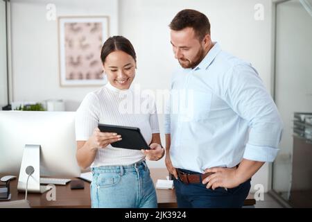 Cosa ne pensate: Una donna d'affari che mostra qualcosa al suo collega sul suo tablet digitale. Foto Stock