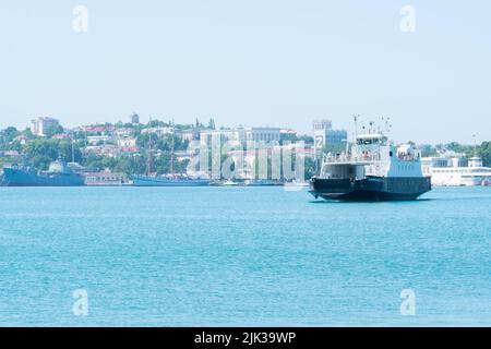 RUSSIA, CRIMEA - LUGLIO 08, 2022: Sevastopol russia città baia mare crimea molo traghetto cielo di trasporto, per paesaggio nero per paesaggio per riva all'aperto Foto Stock