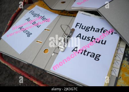 Schkeuditz, Germania. 30th luglio 2022. I documenti simbolici di applicazione per l'espansione dell'aeroporto di Lipsia-Halle si trovano su un trituratore durante un raduno. Circa 250 persone protestano contro la prevista espansione del mozzo del carico aereo. Credit: Sebastian Willnow/dpa/Alamy Live News Foto Stock