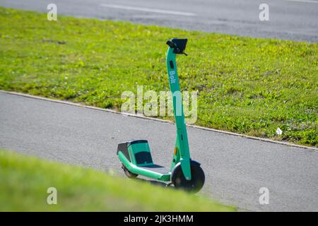 Riga, Lettonia - 29.07.2022: Un nuovo E-scooter BOLT parcheggiato sul marciapiede, pedoni inquietanti. Foto Stock