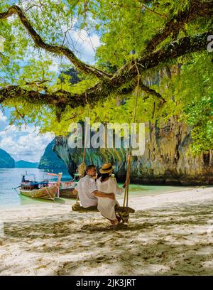 Koh Lao Lading vicino Koh Hong Krabi Thailandia, bella spiaggia con barche a coda lunga, un paio di uomini europei, e una donna asiatica sulla spiaggia. Foto Stock