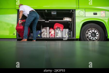 Stoccarda, Germania. 30th luglio 2022. Un uomo può riporre una valigia in un autobus a lunga distanza presso il Busterminal dell'aeroporto di Stoccarda (SAB). Il primo fine settimana di vacanza a Baden-Württemberg è stato occupato negli aeroporti, in strada, nelle stazioni ferroviarie e nelle stazioni degli autobus a lunga distanza. Credit: Christoph Schmidt/dpa/Alamy Live News Foto Stock