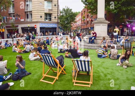 Londra, Regno Unito. 30th luglio 2022. Le persone apprezzano la musica dal vivo sul tappeto erboso artificiale al Seven Dials nel West End di Londra, che è stato bloccato per il traffico per il festival Summer Sessions di un giorno. Credit: Vuk Valcic/Alamy Live News Foto Stock