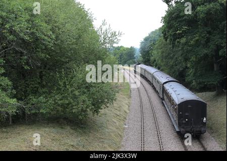 Il treno a vapore del passeggero scompare in lontananza. Foto Stock
