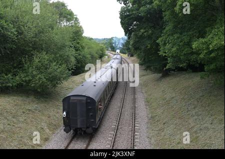 Il treno a vapore del passeggero scompare in lontananza. Foto Stock
