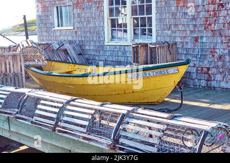 Piccola pesca gialla dorey seduta sul molo fuori di una capanna di pesce meteo nel piccolo villaggio di pescatori di Peggy's Cove Nova Scotia. Foto Stock