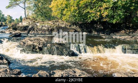 Le splendide cascate di Dochart attraversano la piccola città di Killin, nel Loch Lomond e nel Trossachs National Park. Situato all'estremità occidentale di Loch Foto Stock