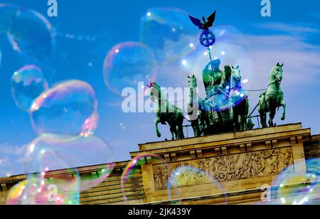 Berlino, Germania. 30th luglio 2022. Un artista di strada attinge bolle di sapone di grandi dimensioni nel cielo di fronte alla porta di Brandeburgo. Credit: Paul Zinken/dpa/Alamy Live News Foto Stock