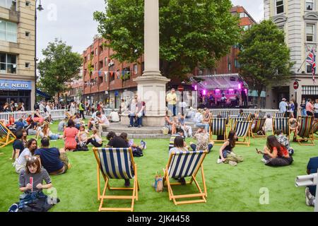 Londra, Regno Unito. 30th luglio 2022. Le persone godono di musica dal vivo su erba sintetica al Seven Dials nel West End di Londra, che è stato bloccato per il traffico per il festival gratuito di una giornata Summer Sessions. (Foto di Vuk Valcic/SOPA Images/Sipa USA) Credit: Sipa USA/Alamy Live News Foto Stock