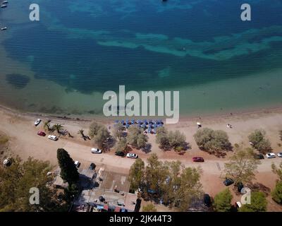 ESTATE GRECA SULLA SPIAGGIA ESTATE GRECA SULLA SPIAGGIA Foto scattata con un drone che mostra la spiaggia di Carathona a Nafplio, Peloponneso sud-orientale in Grecia. La temperatura elevata che prevale è ideale per nuotare sulla splendida spiaggia di Argolis. Sabato 30 luglio 2022. Foto Stock