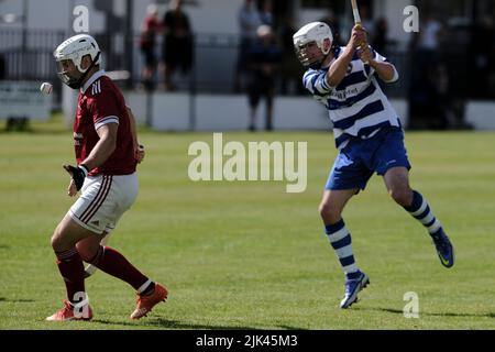 Newtonmore, Regno Unito. 30 luglio 2022. Newtonmore Camanachd Club First Team gioca a Kinlochshiel sulla Eilan nella prima edizione del Mowi. Kingussie (in bianco e blu) contro Kinlochshiel. Punteggio finale 2-2. Campionato di Mowi Premiership. Shinty, o 'Camanachd' in Scottish, è un gioco giocato principalmente nelle Highlands tra squadre che rappresentano villaggi e città. Il gioco è più vecchio della storia registrata della Scozia ed è giocato su un campo d'erba usando una piccola sfera e bastoni (chiamato caman). . Credit: Rob Grey/Alamy Live News Foto Stock