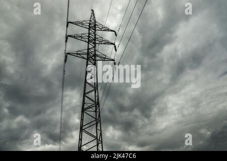 Linea di alimentazione pilone sullo sfondo del cielo nuvoloso scuro Foto Stock