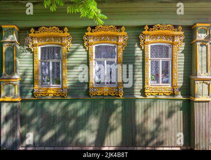 Le belle vecchie finestre con platbands splendidamente progettato finestra su una vecchia casa di legno nella città di Semenov. Regione di Nizhny Novgorod, Russia. Foto Stock