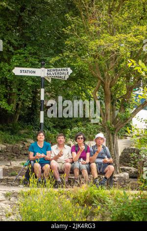 Persone che godono del sole estivo del 2022 presso la località turistica Cumbria di Arnside, a nord di Morecambe Bay UK Foto Stock