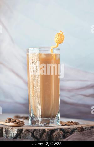 Delizioso latte ghiacciato su un piatto di servizio in legno con chicchi di caffè, primo piano, fotografia di natura morta Foto Stock