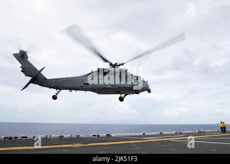 220729-N-CM110-1054 OCEANO PACIFICO (29 luglio 2022) – un elicottero MH-60s Sea Hawk assegnato a Helicopter Sea Combat Squadron (HSC) 23 decola dal ponte di volo a bordo della nave da assalto anfibio USS Tripoli (LHA 7), 29 luglio 2022. Tripoli opera nell'area operativa della flotta USA 7th per migliorare l'interoperabilità con alleati e partner e servire come forza di risposta pronta a difendere la pace e mantenere la stabilità nella regione Indo-Pacific. (STATI UNITI Foto Navy di Mass Communication Specialist 3rd Classe Maci Sternod) Foto Stock