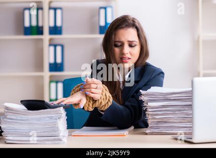 Il giovane bella dipendente legato con corda in ufficio Foto Stock