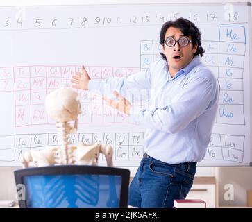 Il giovane insegnante di chimica maschile e scheletro studente Foto Stock