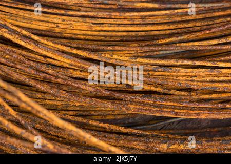 primo piano astratto del rotolo di filo di acciaio arrugginito, preso in profondità poco profonda di campo, industria e concetto di costruzione background Foto Stock