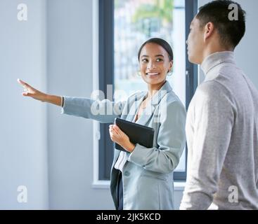 Youll godere della vista. Un agente immobiliare femminile giovane che mostra un cliente una casa. Foto Stock