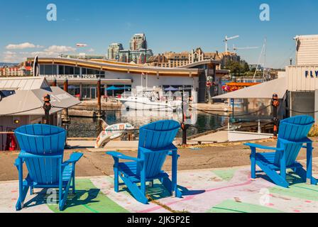 Colorate sedie di legno adirondack. Sedie blu adirondack sulla strada. Foto di viaggio, nessuno Foto Stock