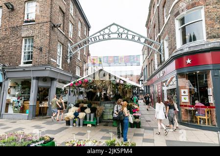 Il mercato di Shambles nella città di York, entrata del mercato con bancarella di fiori fioristi, Yorkshire, Inghilterra, Regno Unito Foto Stock