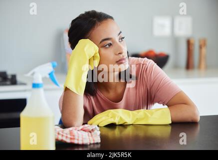 Mi chiedo se mai finito male pulizia. Una giovane donna che prende una forma di pausa pulizia della sua cucina. Foto Stock