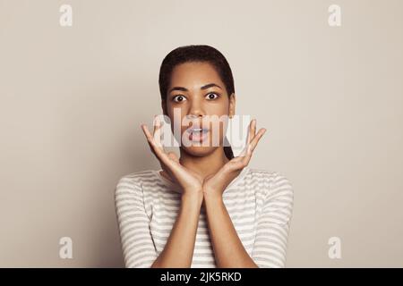 Allegra bella donna afroamericana con bocca aperta, concetto di sorpresa Foto Stock