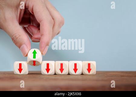 Il cambio di mano con ribaltamento cambia la direzione di una freccia su Cubo in legno , concetto aziendale per una soluzione innovativa Foto Stock