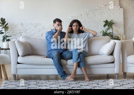 Stanco stressava giovane coppia litigando a casa, seduto sul divano Foto Stock
